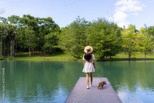 Woman with her dog and walk in the deck over the water pond view