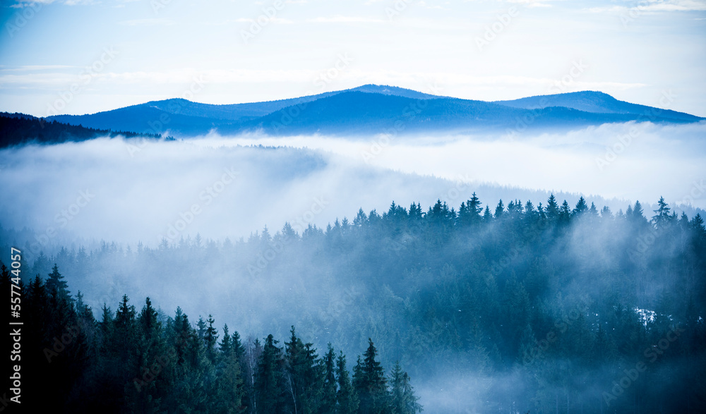 Nebelschwaden vor blauen Bergen