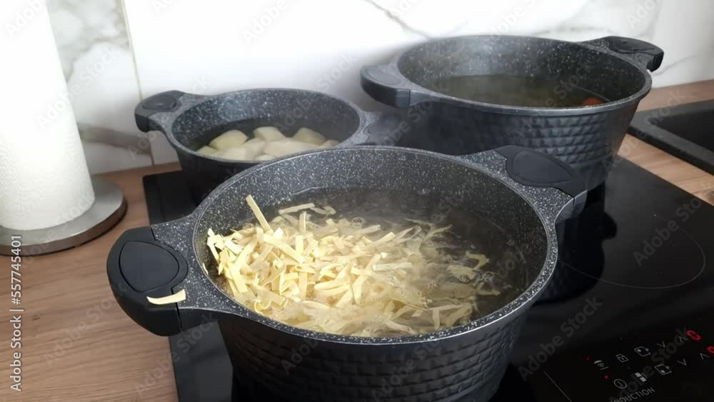 Throwing pasta into a pot of hot water on a stove. Food preparation, cooking dinner, culinary Throwing pasta into a pot of hot water on a stove. Food preparation, cooking dinner, culinary