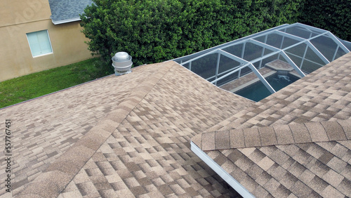 Pool screen enclosure connected to house roof taken from aerial drone uav photo