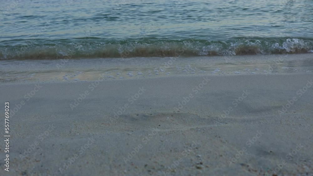 Transparent waves of azure water roll onto sandy shore of beach. Blue water in morning sun of coastline. High quality 4k footage Transparent waves of azure water roll onto sandy shore of beach. Blue water in morning sun of coastline. High quality 4k footage