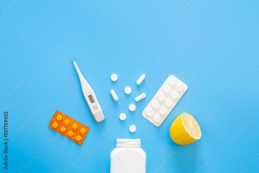Blue background with pills, thermometer and lemon, flat lay. Blue background with pills, thermometer and lemon, flat lay.