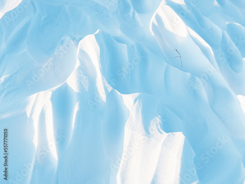 Snow texture. Wind sculpted patterns on snow surface. Wind in the tundra and in the mountains on the surface of the snow sculpts patterns and ridges (sastrugi). Arctic, Polar region. Winter background photo