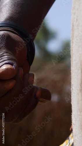 Vertical video of Medium shot of black man hand hitting skin of dundun with wooden stick photo