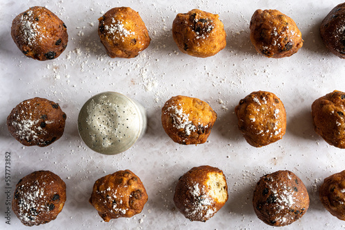 Top down view of Dutch traditional oliebollen with powdered sugar on white background, horizontal