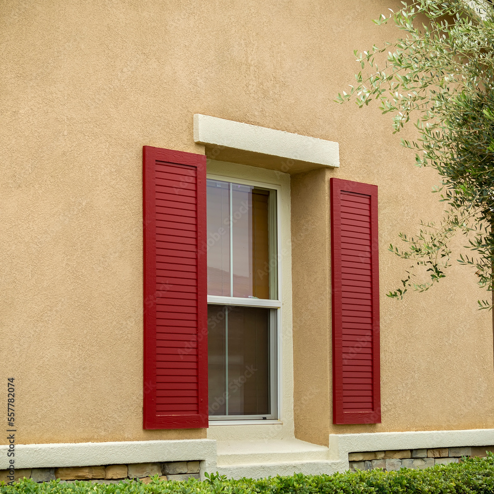 House window close-up in stucco wall with decorative louvered shutter, Menifee, California, USA