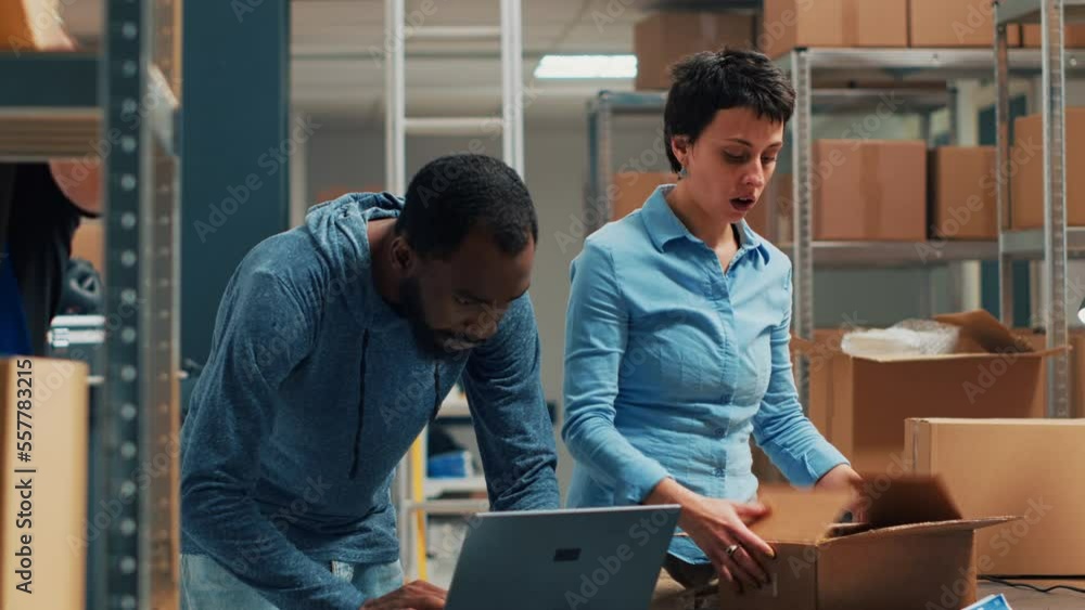Owners team shipping merchandise from storehouse stock and doing quality control. Man and woman working on small business with products shipment, startup distribution. Handheld shot. Owners team shipping merchandise from storehouse stock and doing quality control. Man and woman working on small business with products shipment, startup distribution. Handheld shot.