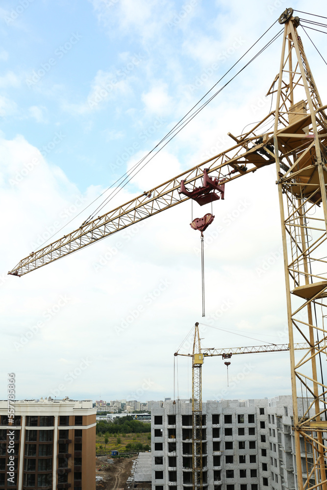 Construction site with tower crane near unfinished building