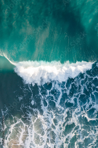 Spectacular aerial view of a surfer taking on waves in a blue ocean