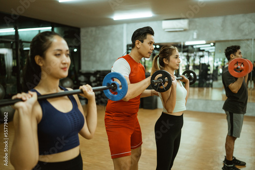 Принти на полотні male instructor instructs young woman on proper spinal positioning when using a