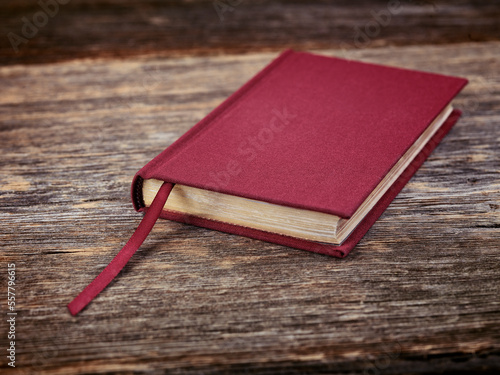 Red hardcover book on wooden background