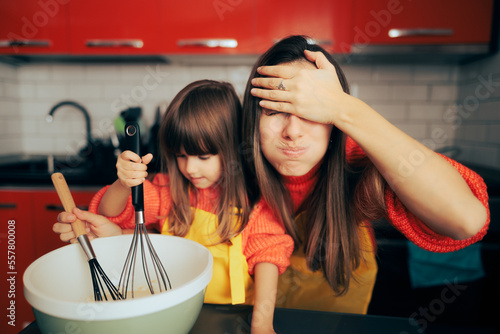 Stressed Mom Supervising her daughter in the Kitchen Cooking. Mother overreacting watching her daughter making desert 
