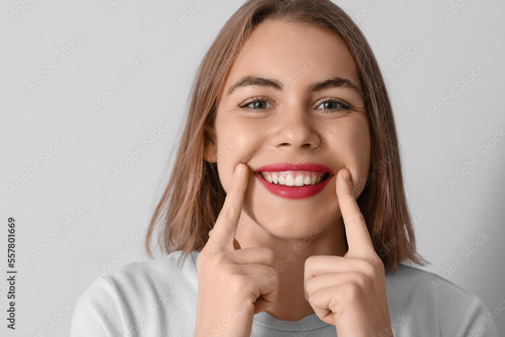 Fototapeta premium Young woman with beautiful smile on grey background, closeup