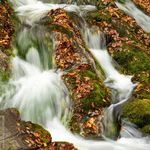 Long exposure waterfall in Smoky Mountain National Park during fall autumn with colorful leaves and silky smooth water. Cades Cove Tennessee