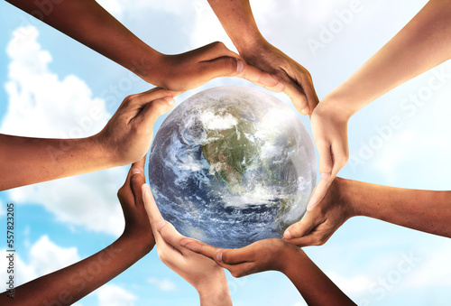 Conceptual symbol of multiracial human hands surrounding the Earth globe. Unity, world peace, humanity concept. World environment day- Earth Day concept. Elements of this image furnished by NASA.