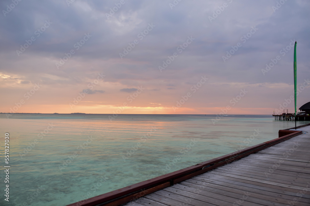 Beautiful Tropical sunset landscape in Maldives island Baa , with infinity Indian ocean sea water view and cloudy skies , perfect Honeymoon travel destination 