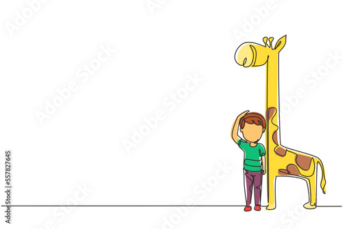 Single continuous line drawing little boy measuring his height with giraffe height chart on wall. Kid measures growth. Child measuring height. Dynamic one line draw graphic design vector illustration