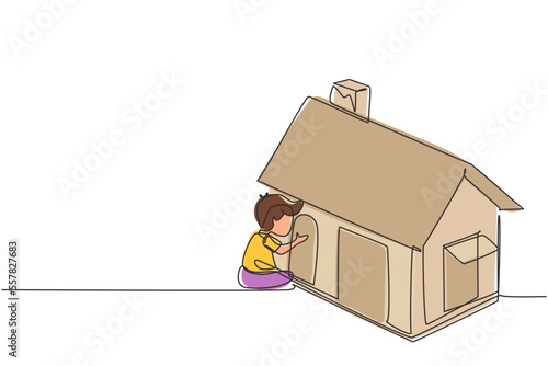 Single one line drawing cute little boy playing in house made of cardboard boxes. Creative child sitting in playhouse. Kid leisure time. Modern continuous line draw design graphic vector illustration