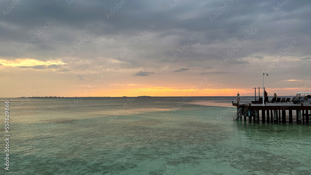 Beautiful Tropical sunset landscape in Maldives island Baa , with infinity Indian ocean sea water view and cloudy skies , perfect relaxing Honeymoon travel destination 