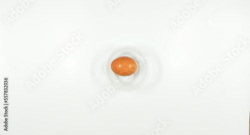 Top view of eggs in clear bowl on white background, isolated
