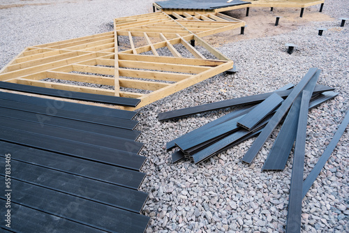 Walking area on screw piles, wooden frame, plastic terrace board, construction work in progress, landscape design
