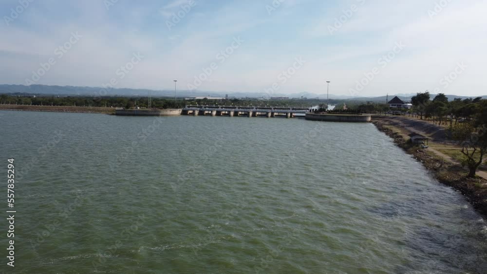 Aerial view of an amazing travel train parked on a floating railway bridge over the water of the lake in Pa Sak Jolasid dam with blue sky at Lopburi, Thailand. Aerial view of an amazing travel train parked on a floating railway bridge over the water of the lake in Pa Sak Jolasid dam with blue sky at Lopburi, Thailand.