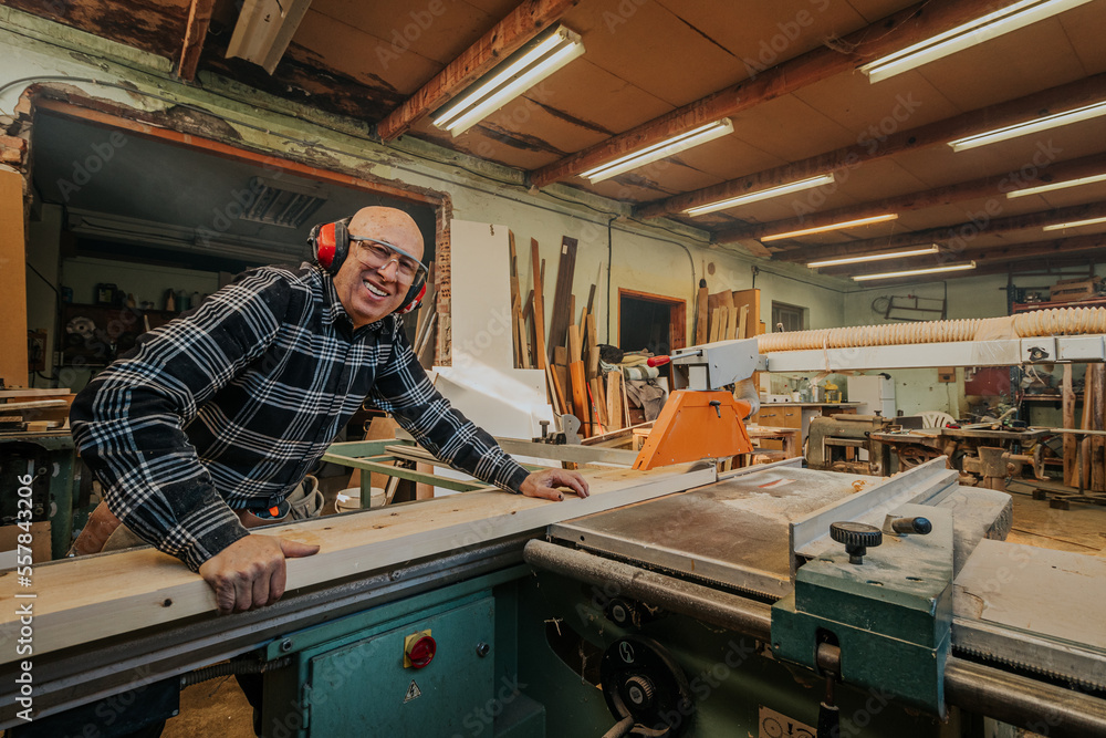 Carpenter cutting wood on circular saw table Carpenter cutting wood on circular saw table