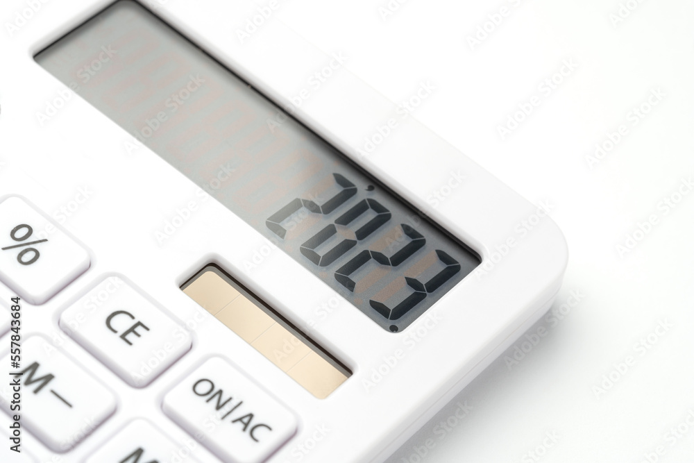 A white calculator with 2023 on the screen. A concept for recording income, expenses and controlling finances.