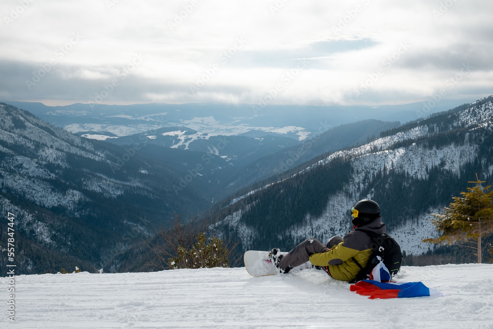 man snowboarder with slovakia flag at ski resort slope