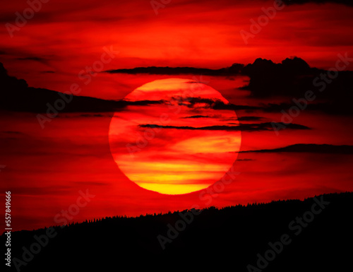Sun setting against fiery red sky