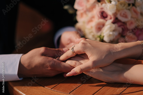 Wedding ring on bride's hand with wedding flowers