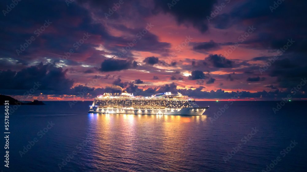 Cruise ship at sea aerial view with dramatic clouds at sunset in the Andaman Sea, Phuket, Thailand