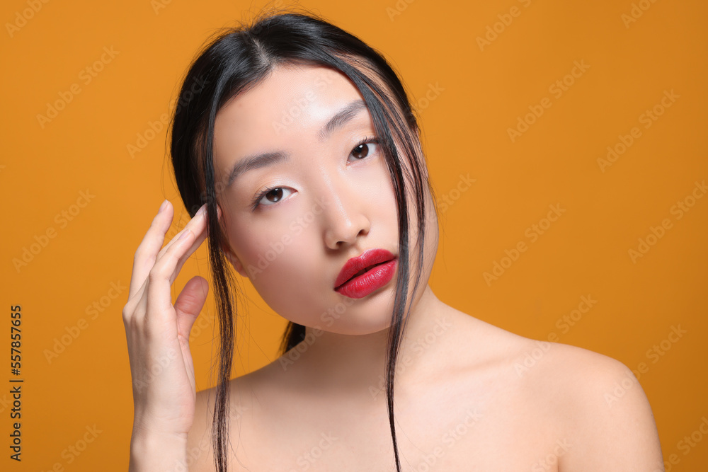 Portrait of beautiful young Asian woman on orange background Portrait of beautiful young Asian woman on orange background