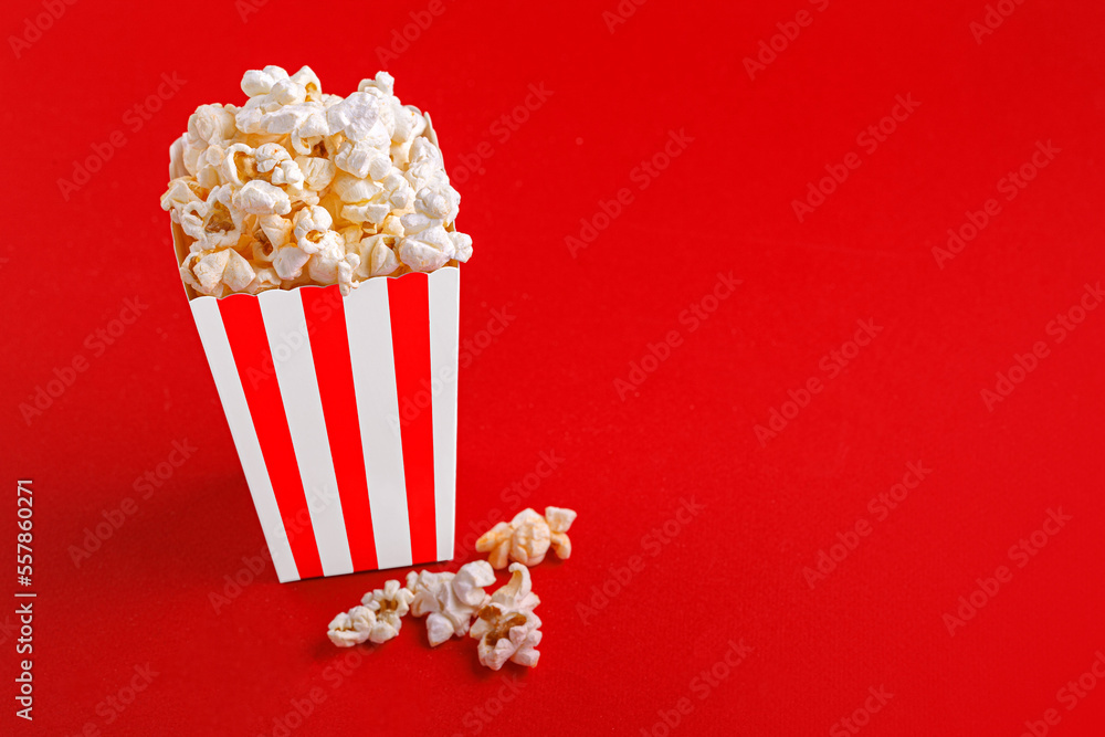 Glass with popcorn on a red background