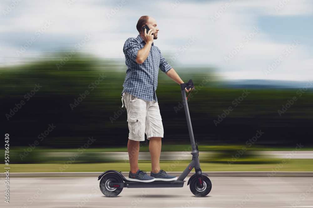 Man riding an e-scooter and having a phone call Man riding an e-scooter and having a phone call