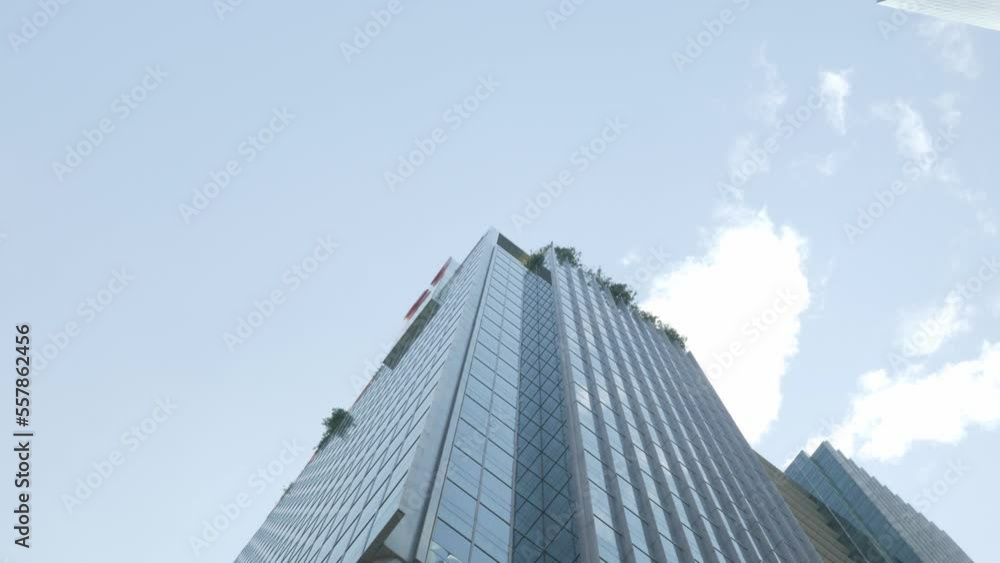 Close-up low angle steadicam shot of modern glass facade office building in business district with glasses wall mirror with blue sky Close-up low angle steadicam shot of modern glass facade office building in business district with glasses wall mirror with blue sky