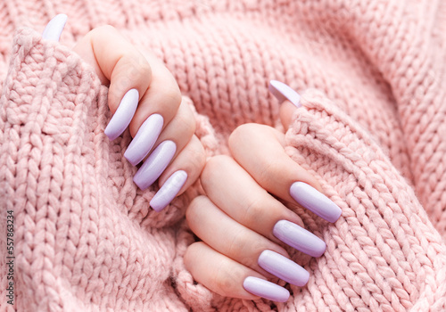 Girl's hands with a soft purple manicure.