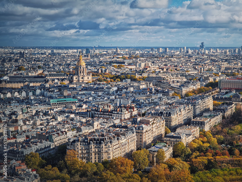 Sightseeing aerial view over the Paris city, France. Les Invalides building with golden dome seen on the horizon. Autumn parisian cityscape