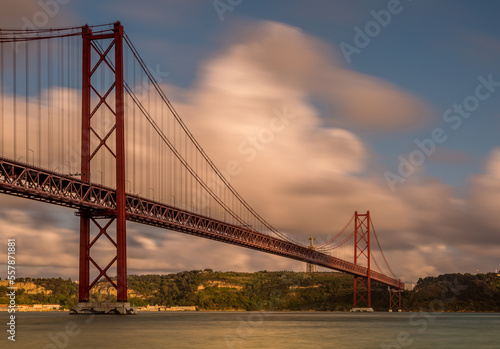 The "25 de Abril" suspension bridge (which translates to the "25th of April" Bridge) and the 'Cristo Rei' (which translates to "Christ the King") 
statue on the banks of the Tagus River in the capital