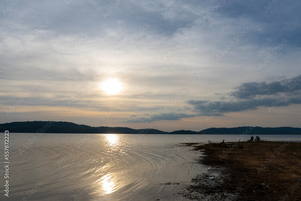 Obraz premium Sunset in the evening at a reservoir behind a dam.