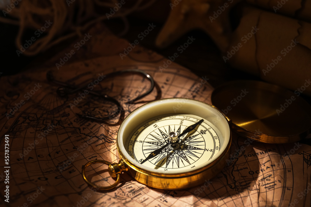 Golden compass and hooks on world map
