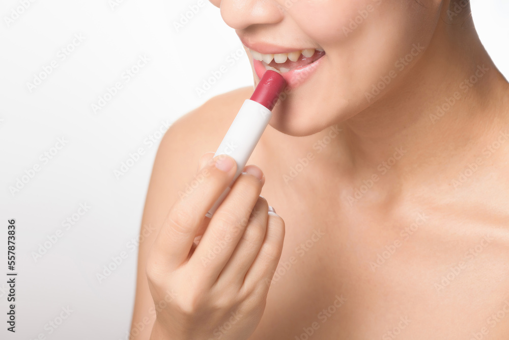 Beautiful portrait young asian woman looking mirror applying makeup lipstick at room. clipping path Beautiful portrait young asian woman looking mirror applying makeup lipstick at room. clipping path