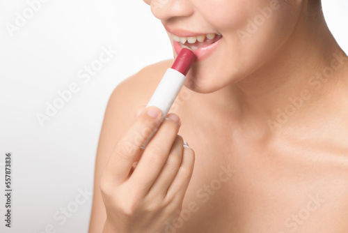 Beautiful portrait young asian woman looking mirror applying makeup lipstick at room. clipping path