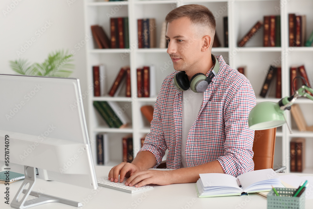 Young man with headphones and computer studying online at home Young man with headphones and computer studying online at home