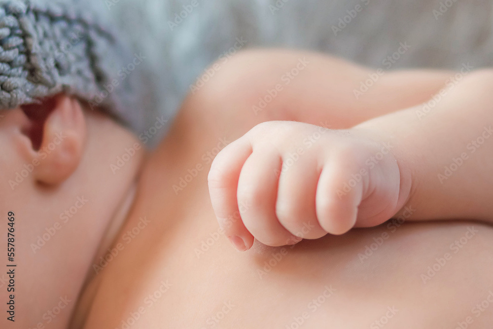 The hand of a newborn clenched into a fist. Family and home concept. Health care, pediatrics. Motherhood. Newborn and parent The hand of a newborn clenched into a fist. Family and home concept. Health care, pediatrics. Motherhood. Newborn and parent