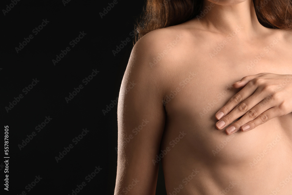 Naked young woman on black background. Breast cancer awareness concept Naked young woman on black background. Breast cancer awareness concept