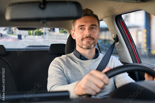 Happy mature man driving car