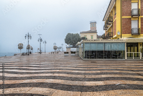 Garda lake  waterfront of the picturesque town of Lazise on Lake Garda in the winter season. Lazise, Verona province, northern Italy - January 21, 2022 photo