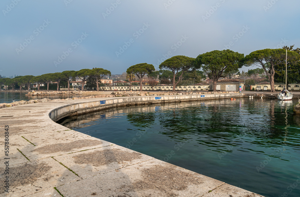Garda lake  waterfront of the picturesque town of Lazise on Lake Garda in the winter season. Lazise, Verona province, northern Italy - January 21, 2022