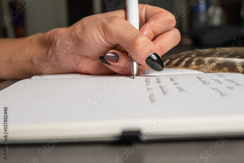 écriture d'une main de femme dans un cahier personnel